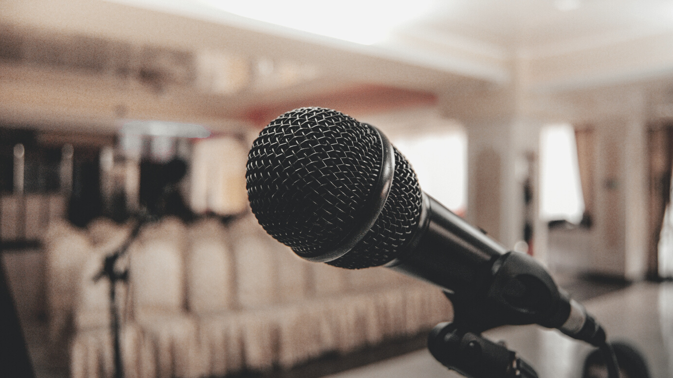 Black microphone in light conference hall